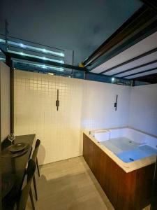 bañera grande en una habitación con mesa en Flat 118 com Hidromassagem - get by side, en João Pessoa