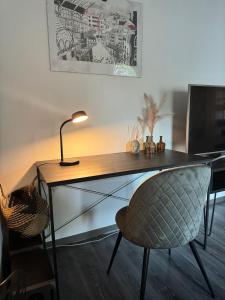 a desk with a chair and a lamp in a room at Cozy Oldhouse Appartment Varenseller in Rheda-Wiedenbrück