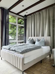 a bed in a room with a large window at Cozy Oldhouse Appartment Varenseller in Rheda-Wiedenbrück +10 photos