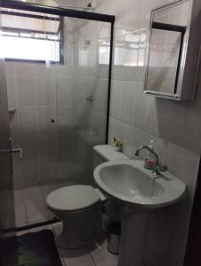 a bathroom with a toilet and a sink and a shower at Nossa kit in Praia Grande