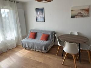 una sala de estar con un sofá y una mesa en Cabourg Proche Thalasso, en Cabourg