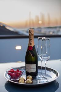 a bottle of wine on a plate with a glass at Floating Sea House SHARK 3 in Portorož