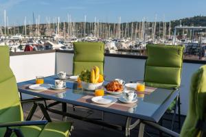 a table with food on a balcony with a marina at Floating Sea House SHARK 3 in Portorož