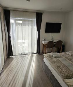 a bedroom with a bed and a desk and a window at Sunny room 1 in Dinkelsbühl
