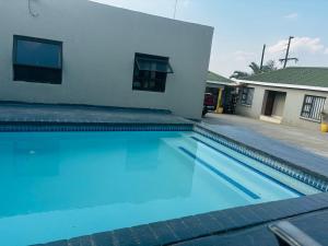 a swimming pool in front of a house at BTV Guesthouse in Hazyview