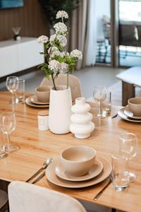 a wooden table with plates and a vase with flowers at Prime Burj Khalifa&Fountain Views 2 Bdr Apartment in Dubai