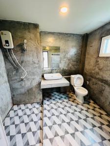 a bathroom with a toilet and a sink and a shower at ริมยมรีสอร์ท in Ban Wang Din