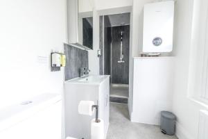 a white bathroom with a sink and a mirror at Luxury Skyfall with FREE PARKING For Families & Business By Prescott Apartments in Bristol +29 photos
