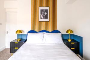 a bedroom with a bed and two tables with lamps at Luxury Skyfall with FREE PARKING For Families & Business By Prescott Apartments in Bristol