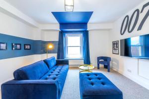 a living room with a blue couch and a window at Luxury Skyfall with FREE PARKING For Families & Business By Prescott Apartments in Bristol