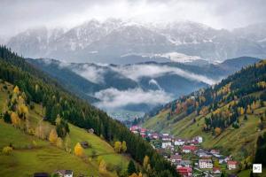 a town on a hill with mountains in the background at Pensiunea Hanul Dorului in Drumu Carului +31 photos