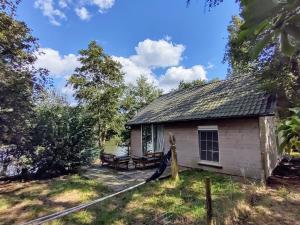 a small white building with a roof at Huisje aan het water in Lichtervelde