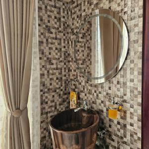 a bathroom with a copper tub and a mirror at Revara Home in Dodoma