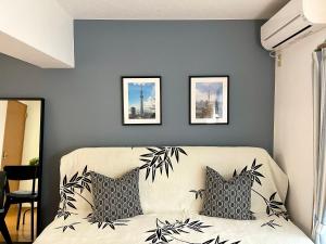 a living room with a couch and two pictures on the wall at 新宿一站5分钟-303-餐馆购物街-安静品质公寓-直达皇居秋叶原 in Tokyo