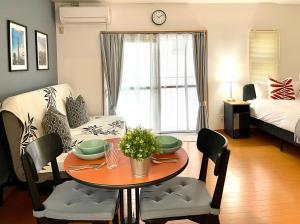 a living room with a table and a bedroom at 新宿一站5分钟-303-餐馆购物街-安静品质公寓-直达皇居秋叶原 in Tokyo