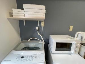 a kitchen with a microwave and a pile of towels at 新宿一站5分钟-303-餐馆购物街-安静品质公寓-直达皇居秋叶原 in Tokyo