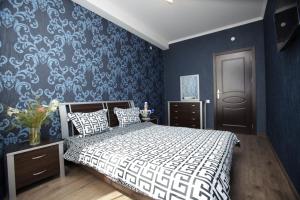 Un dormitorio con una cama y una pared azul. en Niko's Apartments on Shartava Street, en Tiflis