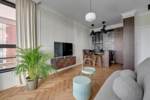 a living room with a couch and a kitchen at DOKI Living by Blue Mandarin Parking & Foodhall in Gdańsk +49 photos