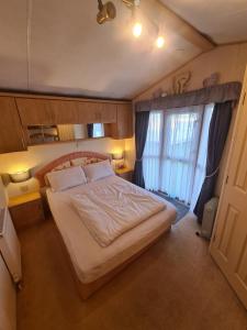 a bedroom with a large bed and a large window at 5 Berth Family Caravan Ingoldmells in Skegness