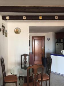 Un comedor con una mesa de cristal y sillas. en Tus vacaciones junto al mar, en Torrevieja
