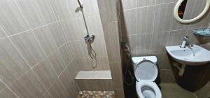 a bathroom with a shower and a toilet and a sink at Raflow Resort Raja Ampat in Tapokreng