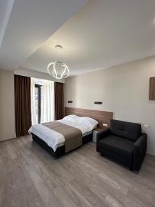 una grande camera da letto con un letto e una sedia di Crystal Loft a Bakuriani