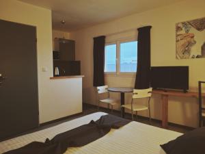 a bedroom with a bed and a table and chairs at Appart'hotel Residella House Room & Kitchen Avignon Le Pontet in Le Pontet