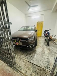 兰奇Bimala Hotel的停放在摩托车旁车库的汽车