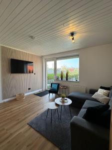 a living room with a couch and a table at FeWo Krabbenbude - modern und fußläufig zum Strand in Dornum