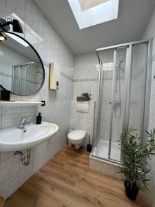a bathroom with a sink and a shower and a toilet at FeWo Krabbenbude - modern und fußläufig zum Strand in Dornum
