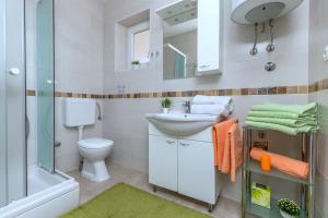 a bathroom with a sink and a toilet and a shower at Apartments Kremenici in Malinska +23 photos