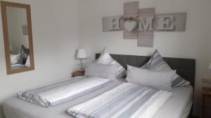 a bed with two pillows and a mirror on the wall at Sommerwind am Kurgarten in Willingen