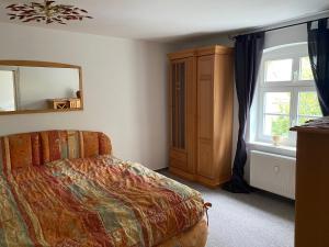 een slaapkamer met een bed, een spiegel en een raam bij Eisern Home 1 in Mittenwalde