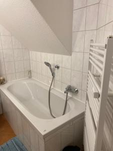 een badkuip met douche in een badkamer bij Eisern Home 1 in Mittenwalde +6 foto's