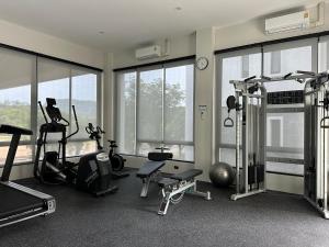 a gym with treadmills and exercise equipment and windows at Title Halo I Sea You Naiyang Pool Gym Sauna in Nai Yang Beach