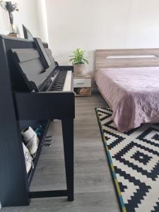 a black piano in a bedroom with a bed at Charmante chambre bucolique - 2ᵉ en option in Chastre-Villeroux-Blanmont +11 photos