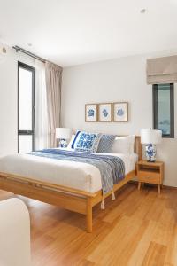 a bedroom with a large bed and two windows at Title Halo I Sea You Naiyang Pool Gym Sauna in Nai Yang Beach +46 photos