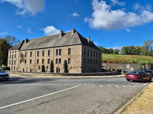 a large brick building on the side of a road at Charmante chambre bucolique - 2ᵉ en option in Chastre-Villeroux-Blanmont