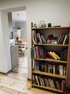 a book shelf full of books in a living room at Domek na wsi kieleckiej in Zborów