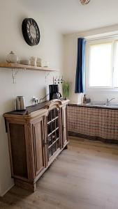 een keuken met een klok aan de muur en een aanrecht bij Landon Cottage in Campénéac +9 foto's