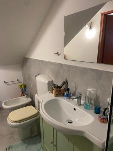 a bathroom with a sink and a toilet and a mirror at Monolocale Zefiro in Elmas