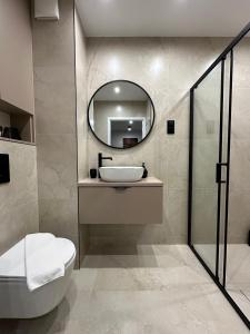 a bathroom with a sink and a mirror at Apartament M&A in Łomża +13 photos