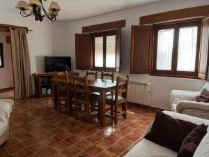 un soggiorno con tavolo, sedie e TV di Casa rural Riópar Viejo a Riópar Viejo