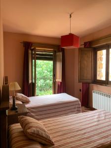 due letti in una stanza con finestra di Casa rural Riópar Viejo a Riópar Viejo