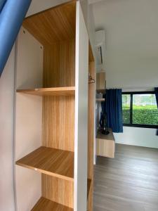 a room with wooden shelves and a window at Pool34 in Ban Bung Toei