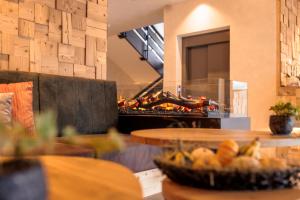a kitchen with a grill with food in front of it at Geniesserhotel Messnerwirt Olang in Valdaora