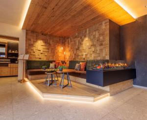 a living room with a couch and a fireplace at Geniesserhotel Messnerwirt Olang in Valdaora +43 photos