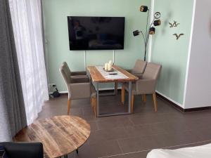 a living room with a table and chairs and a television at Ferienwohnung "Seeperle" Marina Mücheln Geiseltalsee in Mücheln