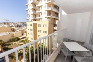 a balcony with a table and a building at kensington in St. Paul's Bay