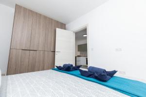 a bedroom with a bed with blue pillows on it at kensington in St. Paul's Bay